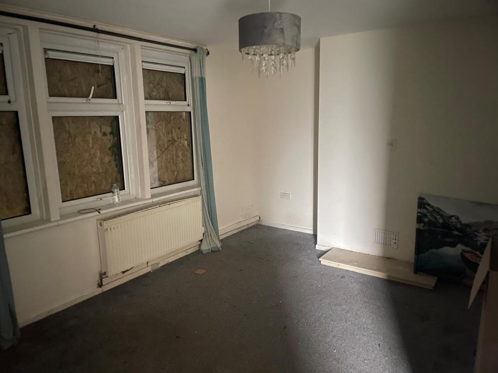 Lot: 110 - PROPERTY ARRANGED AS TWO FLATS - Living room for 11 Trevose Road with boarded up window